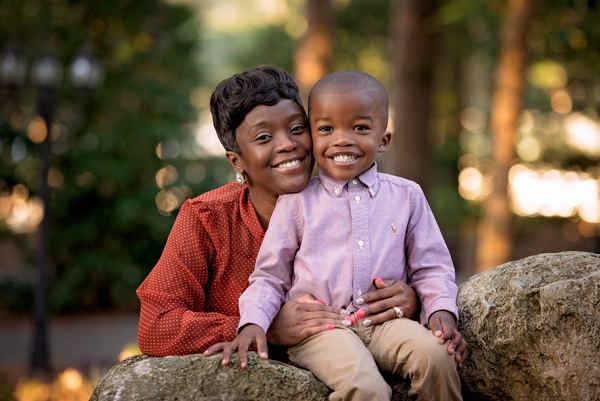 Mother hugging her young son as they sit on a boulder at Dorothy B. Oven Park
