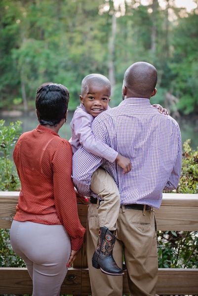 Father holding his son beside mom at a railing overlooking the pond at Dorothy B. Oven Park