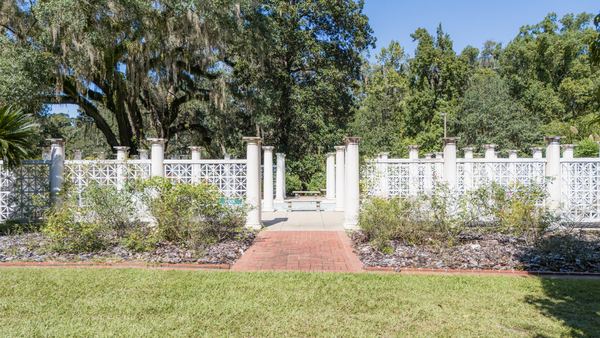 White picket garden fence with a brick walkway entrance at Goodwood