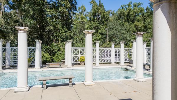 Pool terrace lined with white columns at Goodwood Museum & Gardens