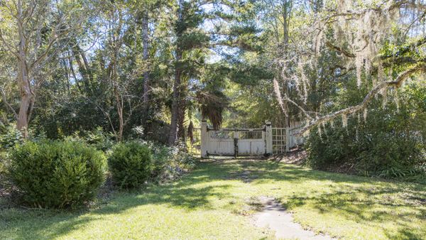 Garden path leading toward a small building in the woods at Goodwood