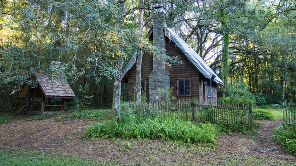 Another view of the Lichgate cottage, its stone chimney and a small wooden shelter