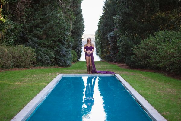 Expectant mother in a purple gown at the far end of the reflecting pool at Maclay Gardens, Tallahassee