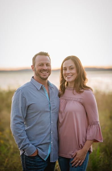 Couple standing together by the lakeshore at golden hour, Millers Landing
