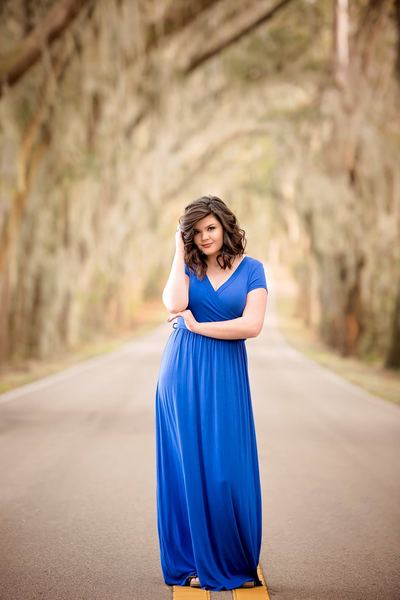 Woman in a long blue dress on the canopy road of moss-draped oaks at Millers Landing