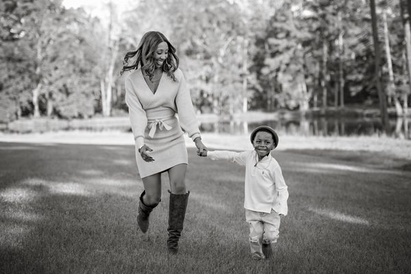 Black-and-white photo of a mother and son running across the lawn at Pebble Hill Plantation