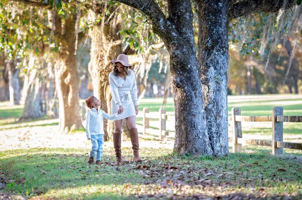 Mother and son walking hand in hand by a large live oak on the grounds of Pebble Hill Plantation, near Tallahassee