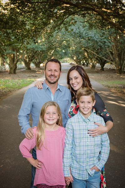 Family portrait standing beneath the oak canopy on the drive at Rose Hill