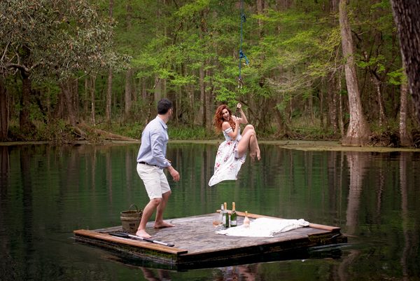 Couple laughing and dancing on a floating wooden dock on the Wacissa River near Tallahassee