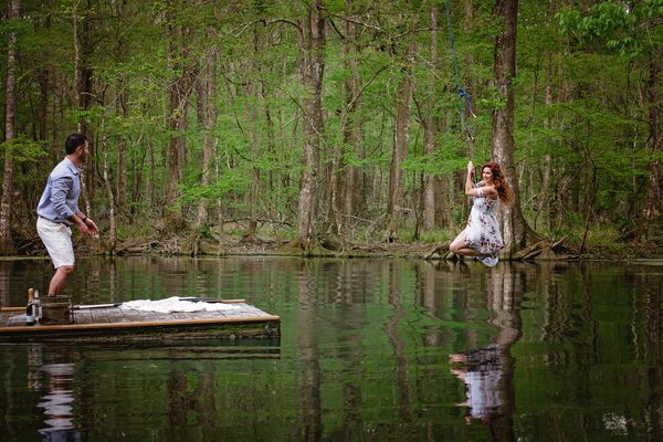 Wide view of a couple on a floating dock surrounded by cypress forest on the Wacissa River
