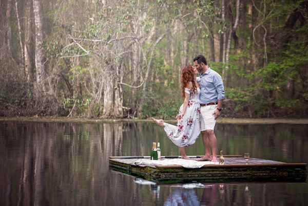 Couple standing on a floating wooden dock among cypress reflections on the Wacissa River